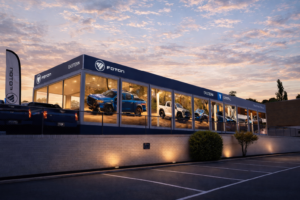 Foton car dealership building at dusk with vehicles in lit showroom windows