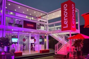 Lenovo pop-up event pavilion lit pink at night with tall Lenovo logo tower